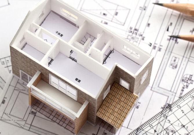 設計図の上に置かれた住宅模型